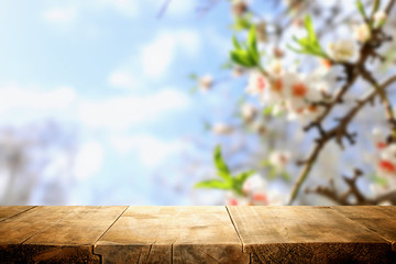 wooden table in front of spring blossom tree landscape. Product display and presentation