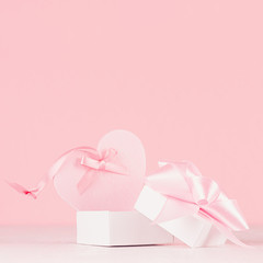 Romance celebration background for Valentine and wedding - cute heart with silk ribbon and gift on white wood board, closeup.