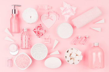 Different cosmetic products and accessories in pink and silver color as decorative pattern on soft light pink background, top view.