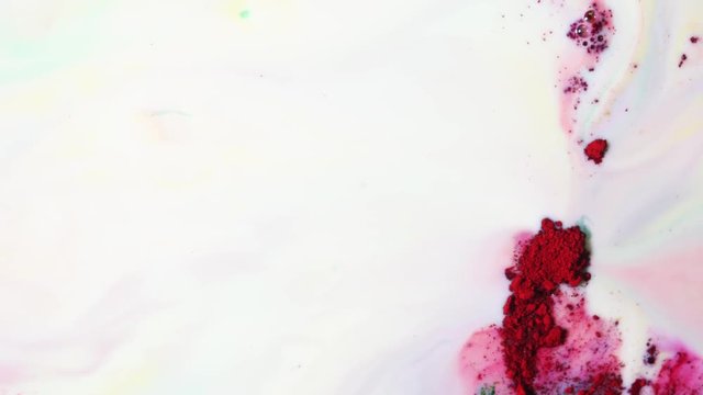 Colorful mixing powders on a white liquid surface with colorful stains, colorful concept. Close-up.