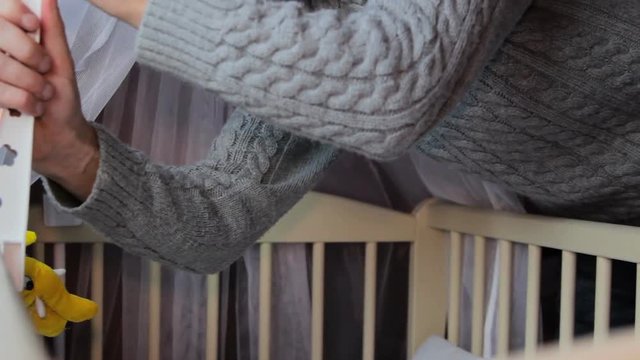 father at the baby crib,father prepares a baby crib for a newborn baby