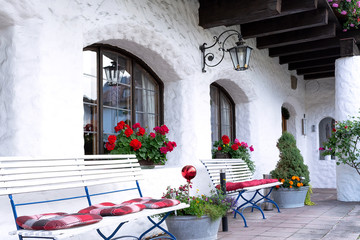 The house territory is decorated with white shops, flowers and forged lanterns.