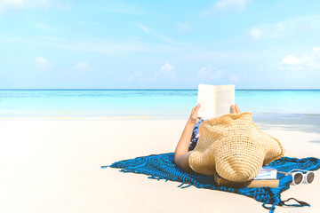 Summer Beach Holiday Woman reading a book on the beach in free time .