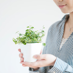 植物を持ち微笑む女性
