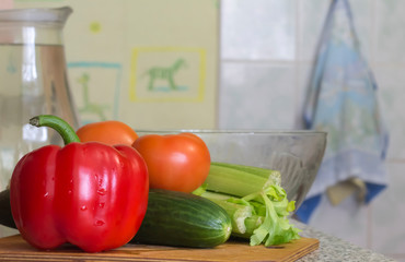 fresh pepper, tomatoes and cucumber with celery on the kitchen table