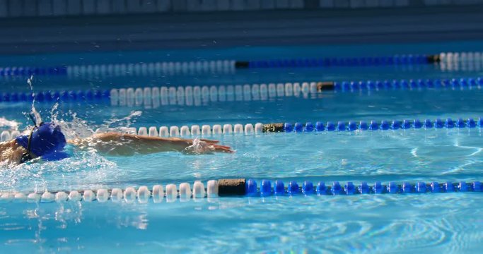 Man and woman swimming together inside the pool 4k