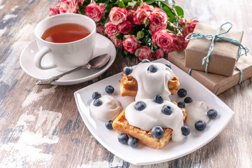 Roses, gifts, Belgian waffles, a cup of tea. Delicious breakfast for the woman he loves. Valentine's day concept