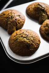 Freshly baked chocolate muffins in bakery form background. Selective focus. Shalow depth of field. 