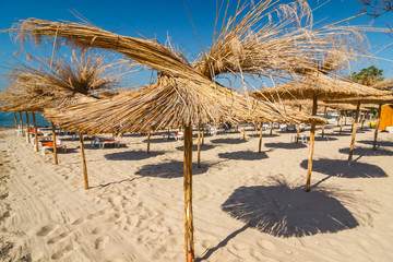 Straw umbrella on empty seaside beach, Bulgaria