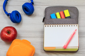 Exercise book on bag-pencil case with color felt pens and marker, sandwich box, apple and...