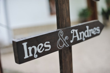 Señal de madera en forma de flecha con las palabras Ines & Andres