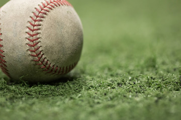 Closeup of old baseball on turf