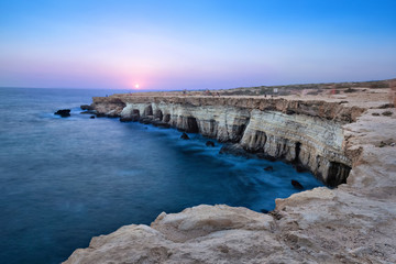Fototapeta na wymiar View of cliff with sea caves at sunset on Cape Greco near Ayia Napa, Cyprus (HDR image)