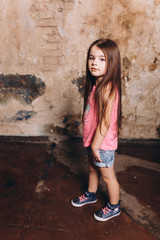 Close up fashion portrait of little cute baby girl posing in studio. Cheerful, fashion girl