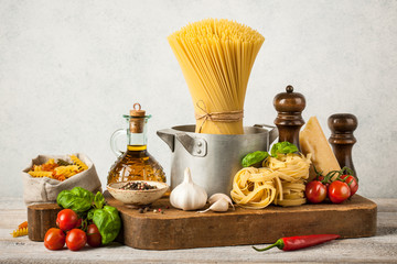 Pasta, spaghetti and ingredients on wooden table
