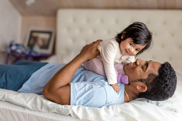 cheerful caring daddy enjoying time with a baby girl,close up side view photo