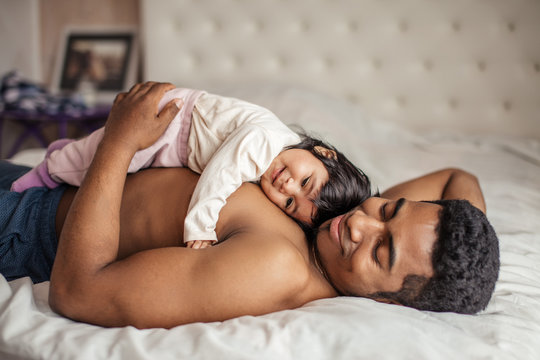 man getting pleasure from lying with favourite daughter, close up side view photo