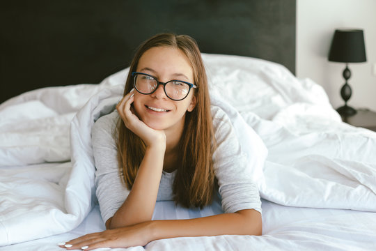 Portrait Of A 12-13-14 Years Old Teenage Girl Wearing Eyeglasses In Bed