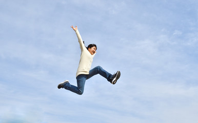 Japanese girl jumping in the blue sky