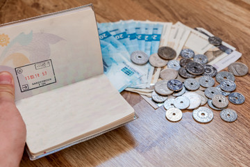 Hand checking Passport with currency coins with cash of nok