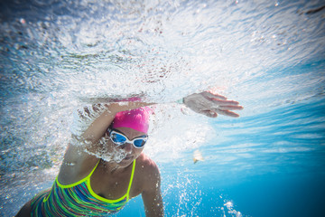 Close up wide angle photo of a female swimmer underwater in a swimming pool