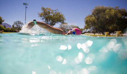 Close up wide angle photo of a female swimmer underwater in a swimming pool