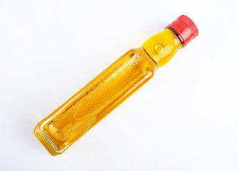 a bottle of golden linseed oil on a white background