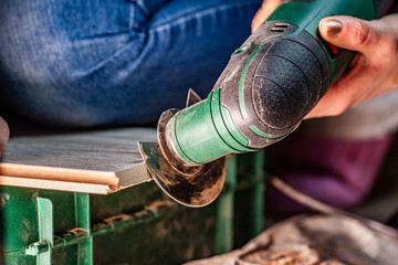 Close up of woman cutting laminate of wooden floor