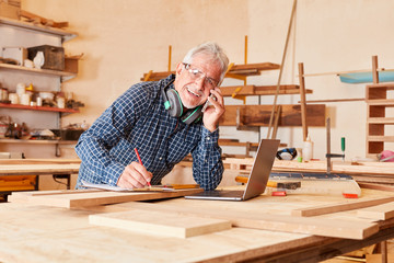 Handwerker mit Laptop Computer und Handy