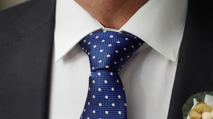 Man adjusting his tie to go wedding