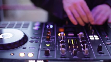 Dj hands manipulating mixer buttons