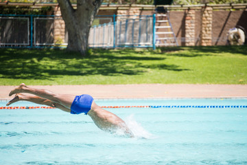 Close up image of a swimmer diving into a swimming pool during training for a big swimming race