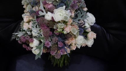 Wedding bouquet on a black leather sofa