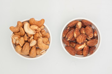 salted Cashews and almonds snack put on white background, Isolate dry and salted cashews and almonds in small white cup