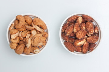 salted Cashews and almonds snack put on white background, Isolate dry and salted cashews and almonds in small white cup