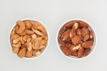 salted Cashews and almonds snack put on white background, Isolate dry and salted cashews and almonds in small white cup
