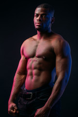 Fototapeta na wymiar Muscular man African bodybuilder. Man posing on a black background, shows his health and perfect shape.