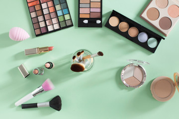 Makeup products on a soft green background
