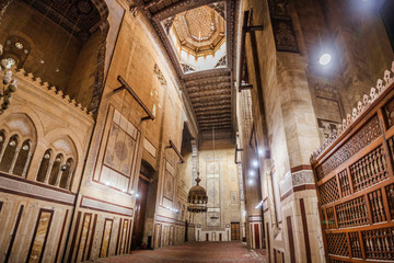 Fototapeta premium CAIRO, EGYPT Interior of Al-Refai Mosque with old decorated stone walls of bricks, colored marble decoration, wooden decorative ceiling, large brass chandeliers and wooden lattice doors, Cairo, Egypt