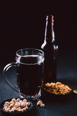 bar table. dark beer and snacks set. restaurant, pub, food concept. delicious drink and salty peanuts. oktoberfest atmosphere, craft brewery background
