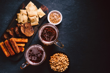 beer and snacks. bar table. restaurant, pub, food concept. delicious lager drink and appetizers set- toasts, nuts, crackers and cheese sticks. friday party atmosphere, craft brewery background
