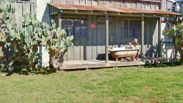 cowboy in bath tub out side old western style cabin scene form gold rush days