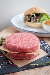 Raw Ground premium beef Burger cutlets homemade on wooden cutting board