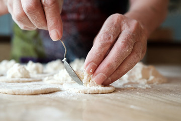 Rolled dough with cottage cheese on wooden table. Process of making homemade dumpling, traditional Russian cuisine
