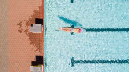 Aerial image of a beautiful female swimmer in a swimming pool getting ready to train.