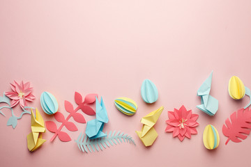 Easter papercraft background, various eggs end bunny and origami paper floral flowers on pink background, flat lay, view from above, blank space for greeting text