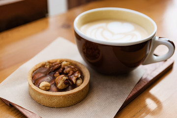 cuo of coffee cappuccino with baked dessert on wooden table