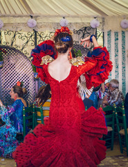  Young and beautiful women wearing flamenco dresses and dancing 