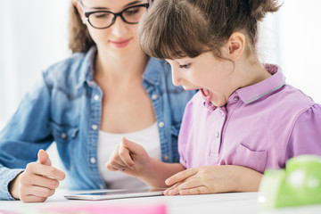 Teacher and girl using a digital tablet