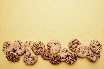 chocolate cookie background, confectionery design concept. cookies on yellow table. sweet food, bakery, dessert backdrop with copy space